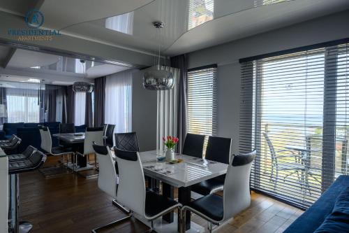 a dining room with a table and chairs at Prezydencki Apartamenty z widokiem na morze in Jarosławiec