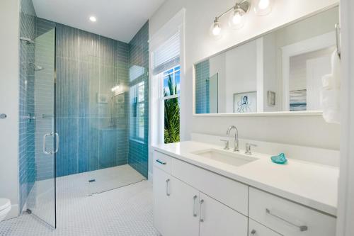 a bathroom with a sink and a shower with a glass door at Beach Fanta Sea in Sarasota