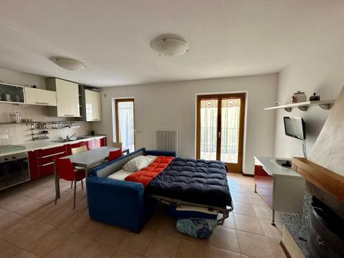 un salon avec un canapé bleu dans une cuisine dans l'établissement Appartamento di Montagna a Polsa Brentonico, à Prada