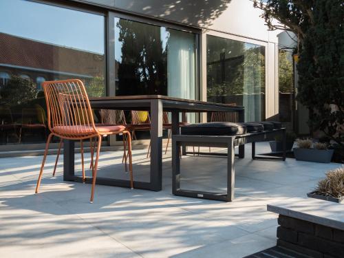 a table and two chairs and a bench on a patio at Villa Ernest in Ypres