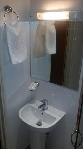 a bathroom with a white sink and a mirror at Arriva Hotel in London