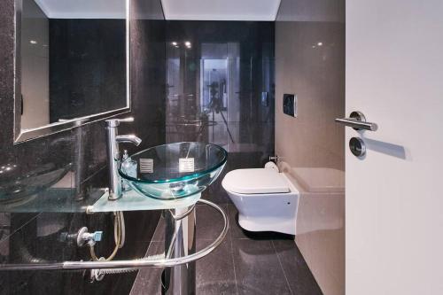 een badkamer met een glazen wastafel en een toilet bij Casa Verao in Estômbar