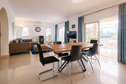 a living room with a wooden table and chairs at Casa Verao in Estômbar