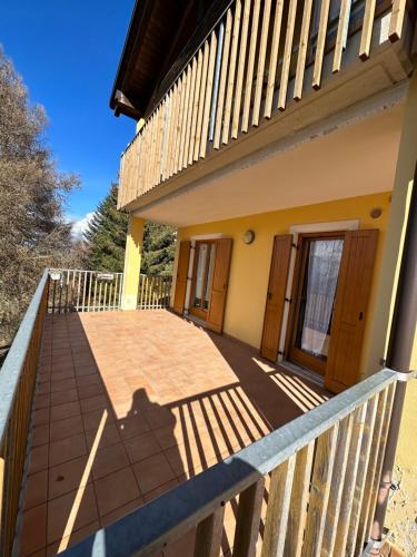 a balcony of a house with a wooden deck at Appartamento di Montagna a Polsa Brentonico in Prada