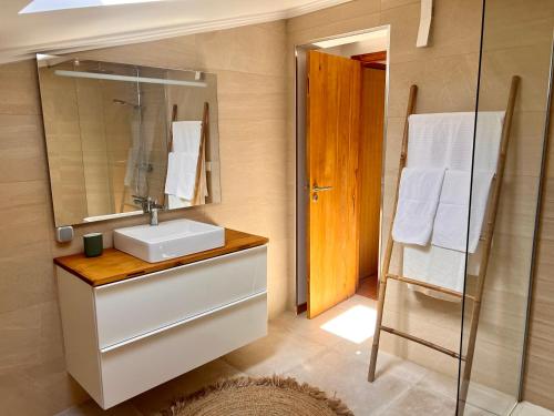 uma casa de banho com um lavatório e um espelho em Casa da Pedreira em Vila Baleira