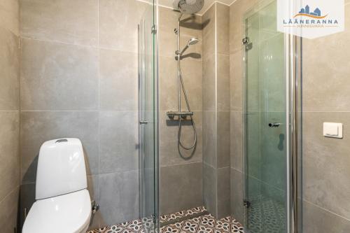 a bathroom with a glass shower with a toilet at Promenaadi apartament in Haapsalu