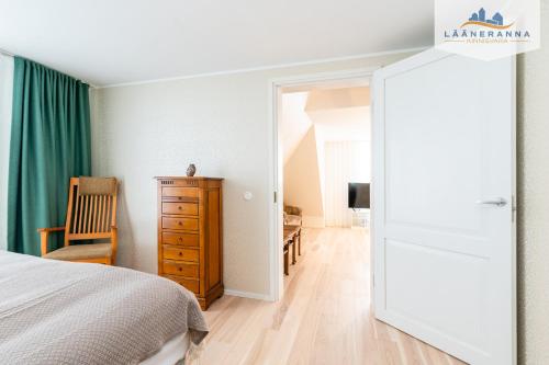 a bedroom with a bed and a chair and a mirror at Promenaadi apartament in Haapsalu