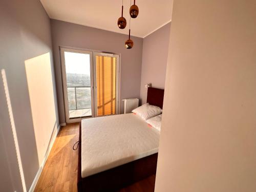 a bedroom with a bed and a large window at 16 Floor nad morzem - prawy in Gdańsk