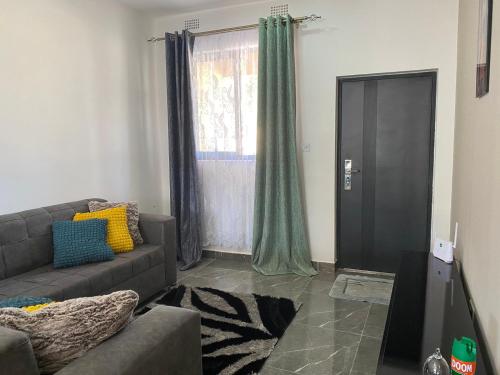 ein Wohnzimmer mit einem Sofa und einem Fenster in der Unterkunft Peaceful Hills Self Catering Holiday House in Lusaka