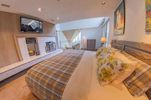 a large bedroom with a bed and a fireplace at Pinnacle Ridge 05 - Ski In Ski Out, Private Hot Tub, Gas Fireplace in Whistler