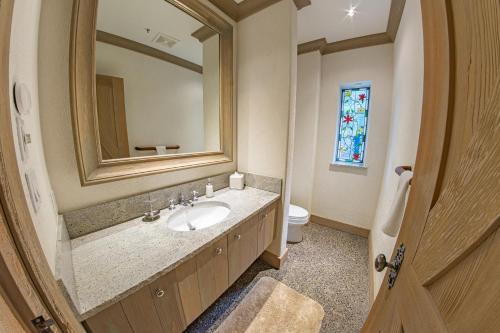 a bathroom with a sink and a mirror and a toilet at Pinnacle Ridge 05 - Ski In Ski Out, Private Hot Tub, Gas Fireplace in Whistler