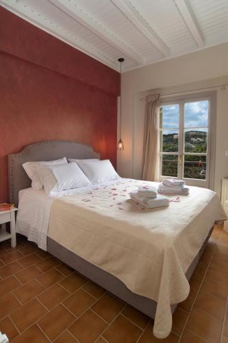 a bedroom with a large bed and a window at Magnolia Apartments in Fiskardho
