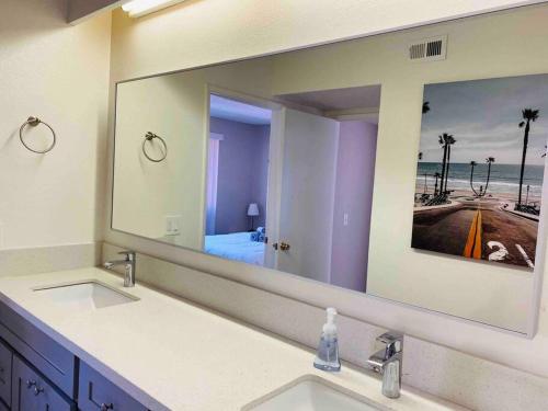 a bathroom with two sinks and a large mirror at Beautiful home near Disneyland. Entire place! in Orange