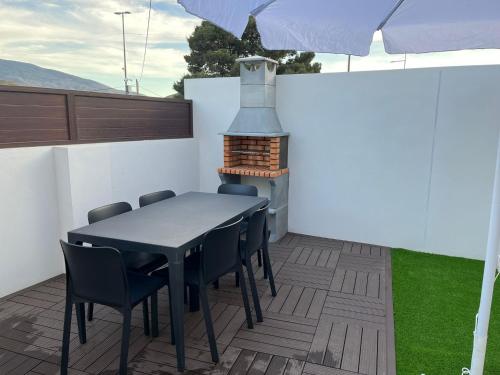 una mesa y sillas en un patio con chimenea en Casa La Zurita, en Tabernas