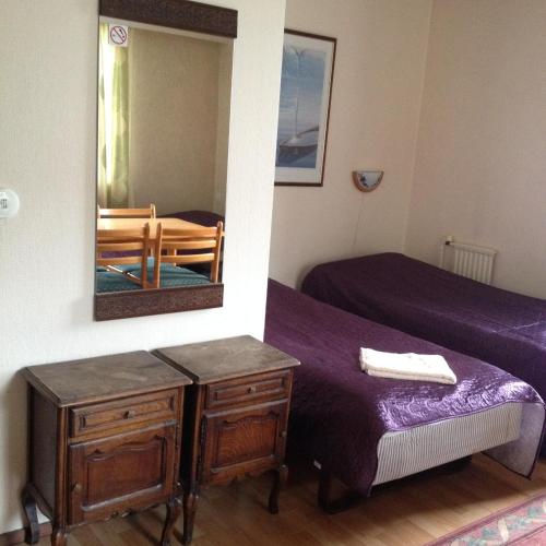 a bedroom with a mirror and a bed and a table at Hotel Lamminpää in Tampere