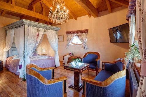 a bedroom with a bed and chairs and a chandelier at Grand Farma Michael in Netvořice