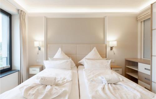 two beds in a room with white sheets and pillows at Prince in Binz