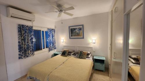 Sitio de CalahondaにあるELENA flat A little paradise right on the BEACHのベッドルーム1室(ベッド2台、シーリングファン付)