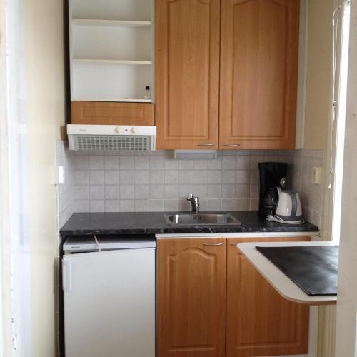 a small kitchen with wooden cabinets and a sink at Hotel Lamminpää in Tampere