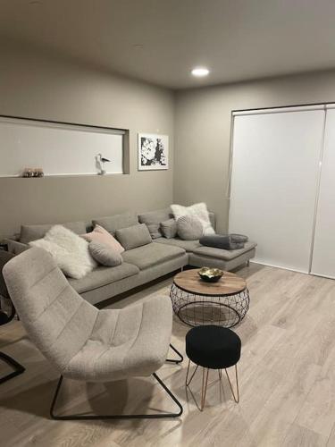 uma sala de estar com um sofá, cadeiras e uma mesa em Beautiful apartment near Airport em Njarðvík