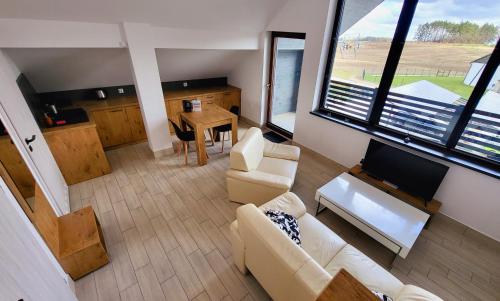 ein Wohnzimmer mit einem Sofa, einem TV und einem Tisch in der Unterkunft Hotel Konopielka in Zblewo