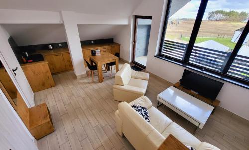 a living room with a couch and a tv and a table at Hotel Konopielka in Zblewo