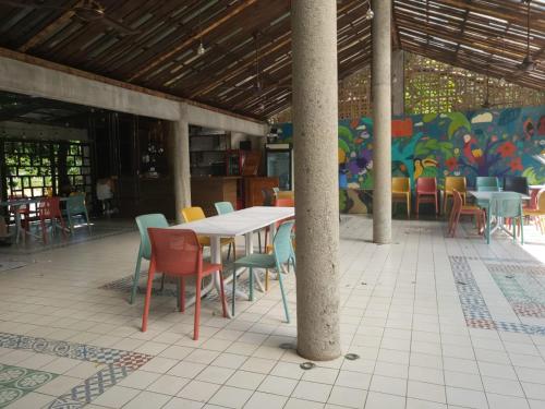 a table and chairs in a restaurant with a mural at Hotel Azul Esmeralda in Teapa