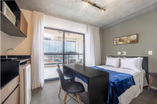 um quarto com uma cama, uma secretária e uma janela em 360 Vita Bom Retiro em São Paulo