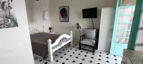una camera con un letto bianco e una sedia di DISTILLERIE a Tartane