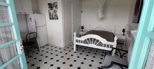 a kitchen with a white and black floor and a refrigerator at DISTILLERIE in Tartane