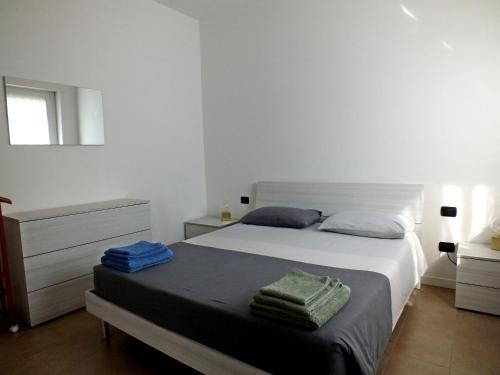 a bedroom with a white bed with two towels on it at Lake Como Casa la Rosa apartment Iris in Abbadia Lariana
