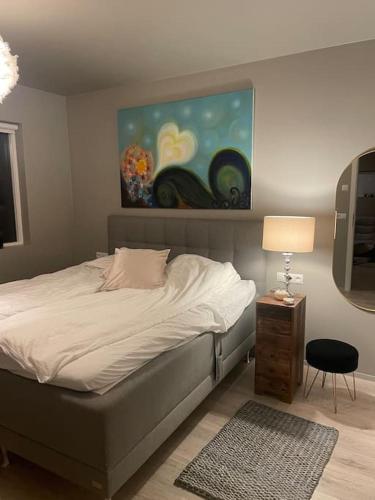 1 dormitorio con 1 cama y una pintura en la pared en Beautiful apartment near Airport en Njarðvík