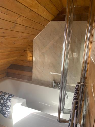 baño con bañera y techo de madera en Little Barn ideal for short stays, en Bexley