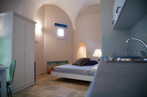 普利亞區格拉維納的住宿－Le Stanze di Finya，一间带床和水槽的小卧室