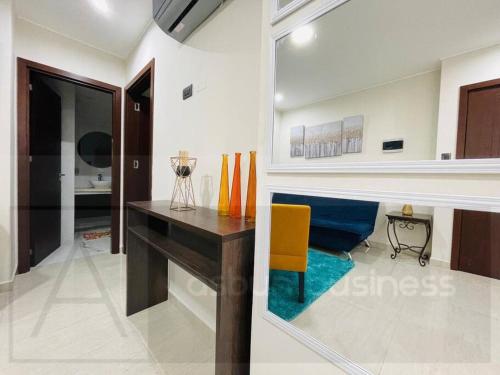 a living room with a desk and a yellow chair at Yovanna Elegante Apartamento 1 dormitorio in Santa Cruz de la Sierra