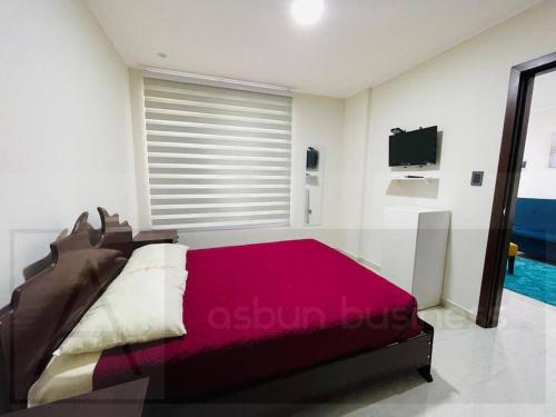 - une chambre avec un lit et une couverture rouge dans l'établissement Yovanna Elegante Apartamento 1 dormitorio, à Santa Cruz de la Sierra