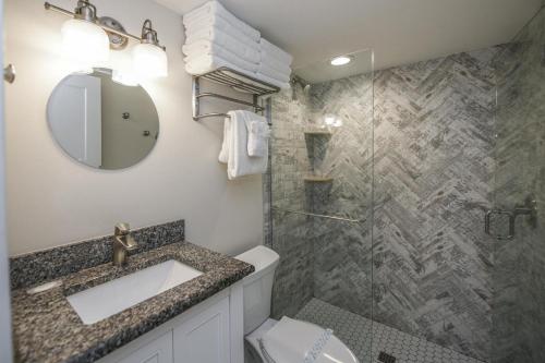 uma casa de banho com um lavatório e um chuveiro em The Mahi em Siesta Key