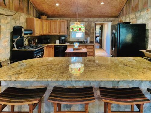 a kitchen with a large counter top in a room at The Camp Blanco by Lodgewell - Riverfront retreat 2 Homes, Bunk House, Game Room & more in Blanco