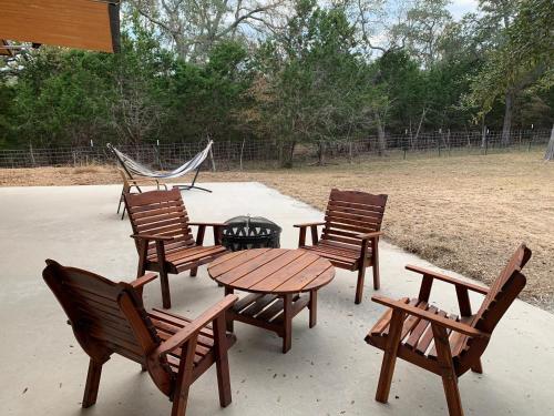 a group of chairs and a table and a hammock at The Camp Blanco by Lodgewell - Riverfront retreat 2 Homes, Bunk House, Game Room & more in Blanco