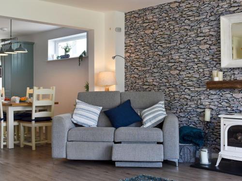 a living room with a couch and a stone wall at Blue Haven in Westward Ho