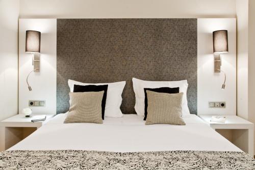 1 dormitorio con 1 cama blanca grande y 2 lámparas en Up Suites Bcn, en Barcelona