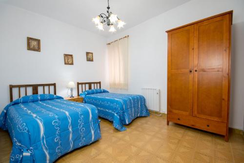 a bedroom with two beds and a cabinet at Apartamento Paco entre Valencia y Castellón in Benafer