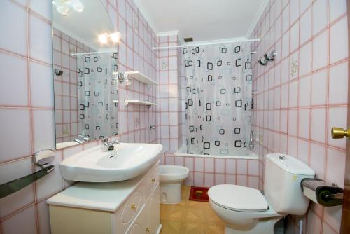 a pink bathroom with a sink and a toilet at Apartamento Paco entre Valencia y Castellón in Benafer