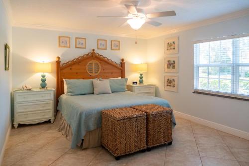 um quarto com uma cama e duas mesas de cabeceira e uma janela em Royal Palm #1B em Siesta Key