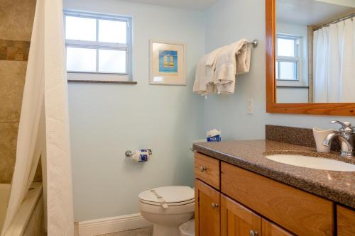uma casa de banho com um WC, um lavatório e um espelho. em Royal Palm #1B em Siesta Key