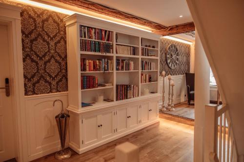 a library with white book shelves filled with books at AnaCapri Gästehaus Venezia in Ueckermünde