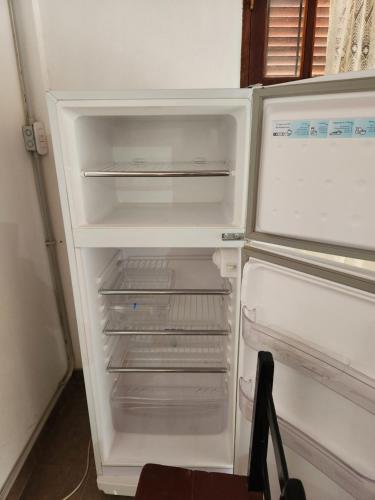 - un réfrigérateur vide avec une porte ouverte dans la cuisine dans l'établissement Casa de Haydee, à Cachí