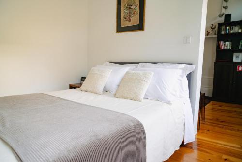 1 dormitorio con 1 cama blanca y 2 almohadas en Bolhão Studio, Porto, en Oporto