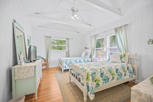 a bedroom with two beds and a tv and windows at Beach Side Babe in Sarasota