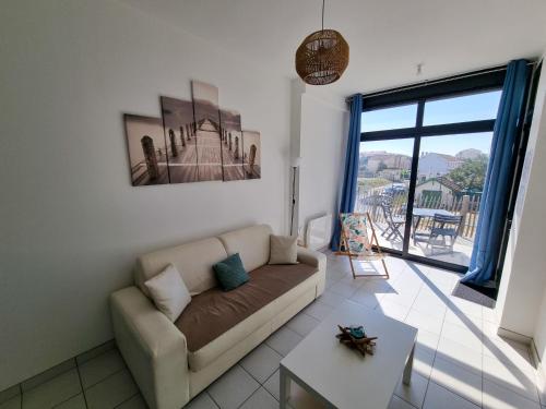 a living room with a couch and a large window at A 200m de la plage - L'Océan - in Mimizan-Plage